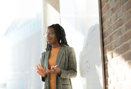 A woman standing in front of a white board