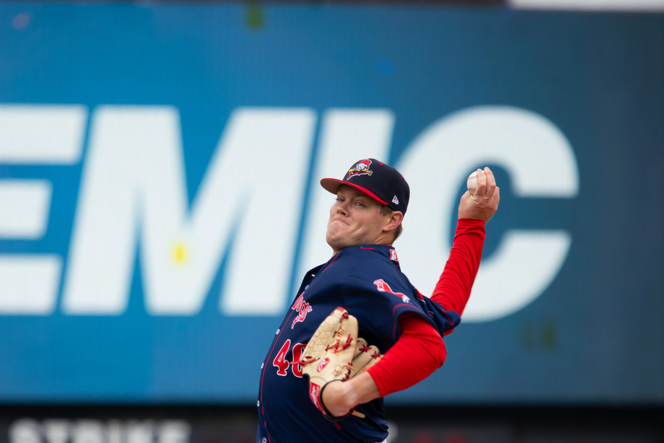 a man in a Sea Dogs uniform throwing a baseball
