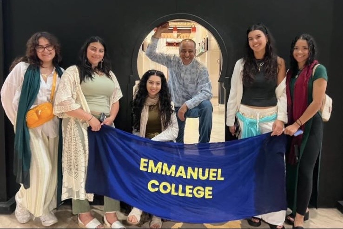 Morocco trip students pose with an Emmanuel College banner in Morocco