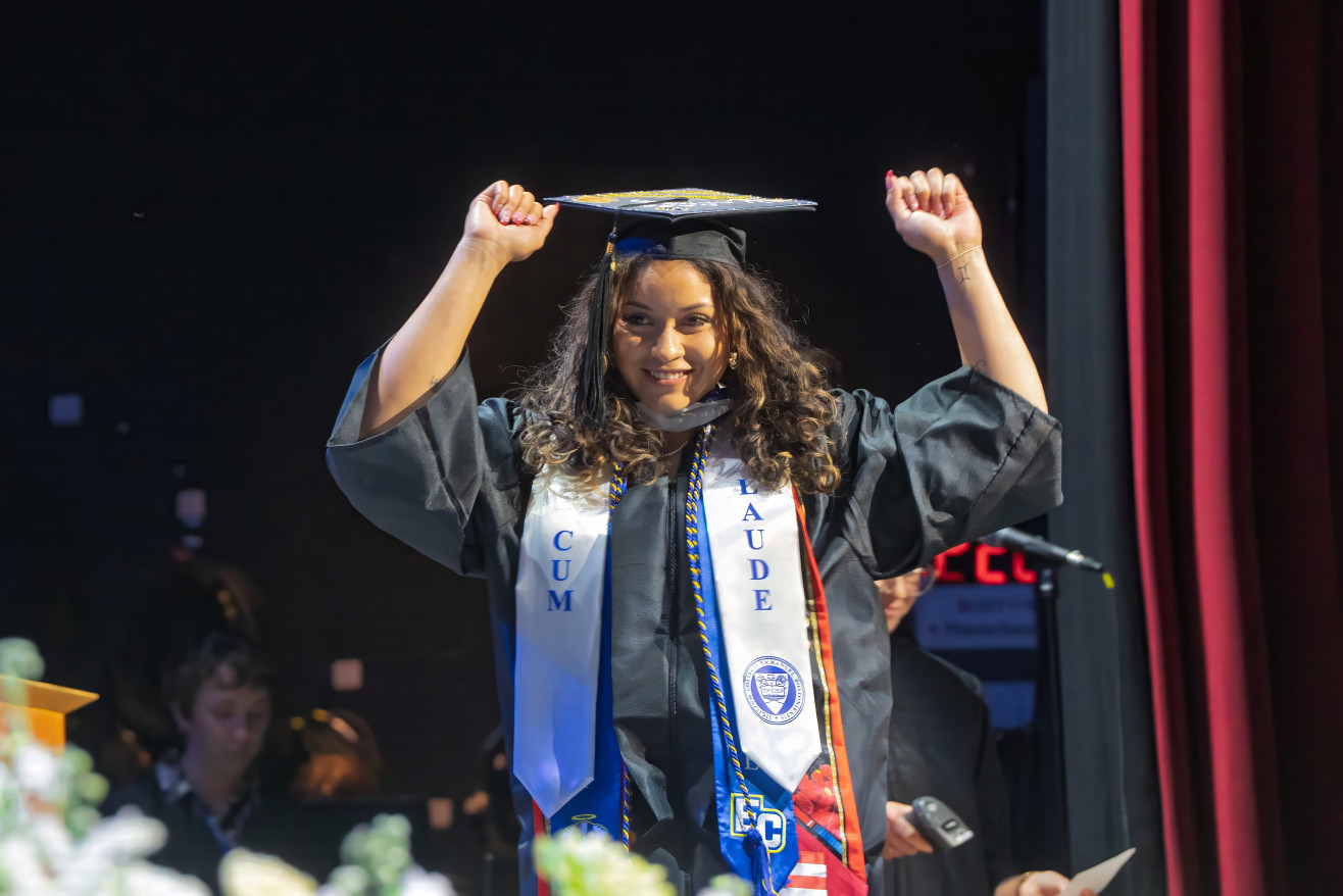 a young woman celebrates before receiving her degree